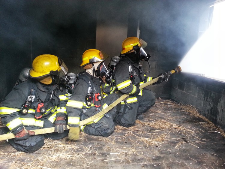 Three Blacksburg Firefighters putting out fire during a training